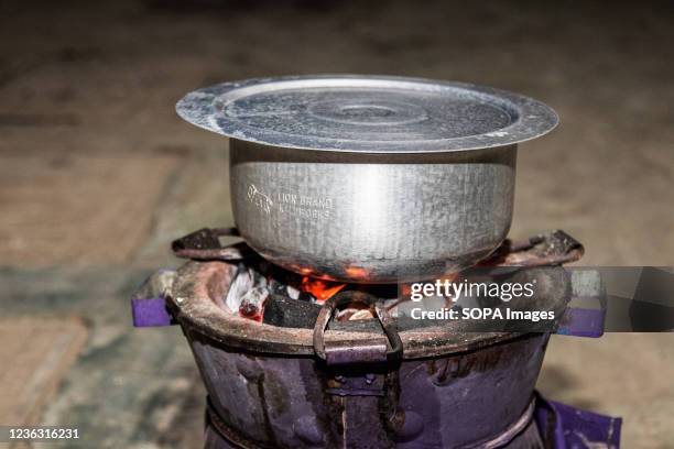 Charcoal stove is seen with a covered aluminum cooking pot. Trees capture carbon dioxide from the atmosphere and convert it into biomass through the...
