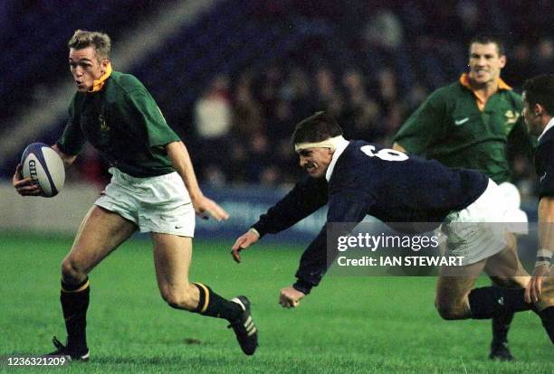 Percy Montgomery of South Africa leaves the Scottish captain Rob Wainwright behind during their rugby international at Murrayfield 06 December....