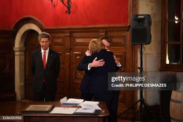 France's President Emmanuel Macron congratulates outgoing German Chancellor Angela Merkel , flanked by her husband Joachim Sauer during the ceremony...