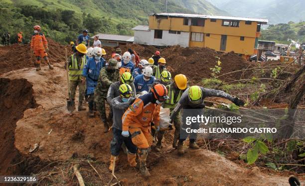 Emergency workers carry a body out of the scene where a mudslide buried two houses in Mallama, Narino province, Colombia, on November 3, 2021. - At...