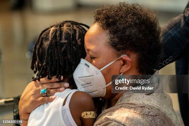 Natasha Greaves holds her daughter, Laila Greaves after Laila received a Pfizer-BioNtech Covid-19 vaccine from firefighter Luke Lindgren on November...