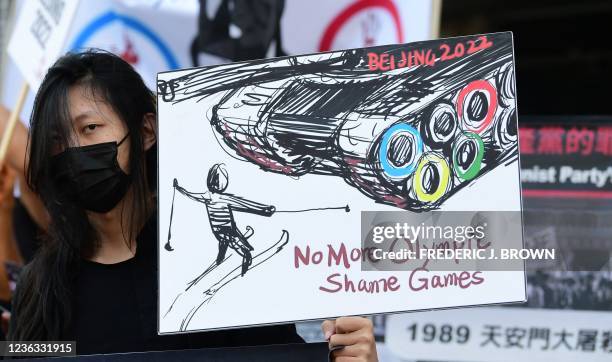 Woman holds a sign as activists rally in front of the Chinese Consulate in Los Angeles, California on November 3 calling for a boycott of the 2022...