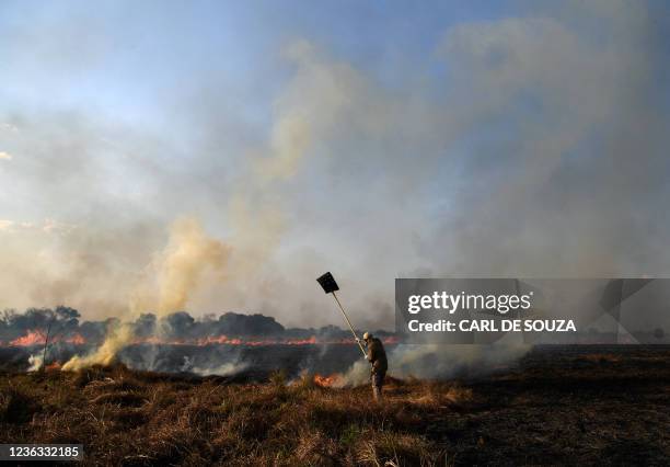 Conservationist of the NGO Panthera fights a fire in Porto Jofre, Pantanal, Mato Grosso state, Brazil, on September 4, 2021. - The Amazon basin has,...