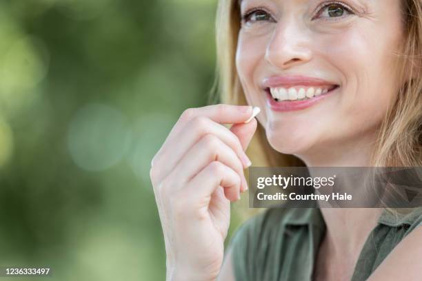 笑顔の女性は口までビタミンを保持します - ビタミンb3 ストックフォトと画像