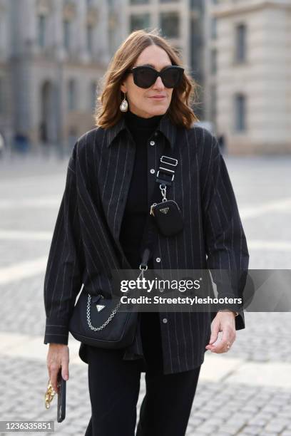 Influencer Annette Weber wearing an anthracite off-white pinstriped blouse by Seidensticker, a black phone case with a gold chain by glam-o-meter, a...