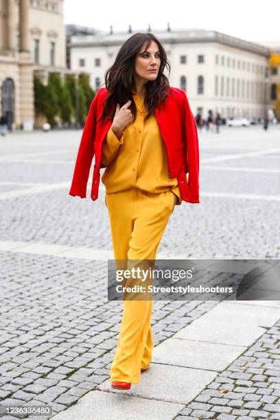 Actress Bettina Zimmermann wearing a yellow blouse by Seidensticker, yellow pants by Seidensticker, a red leather biker jacket and red pumps during a...