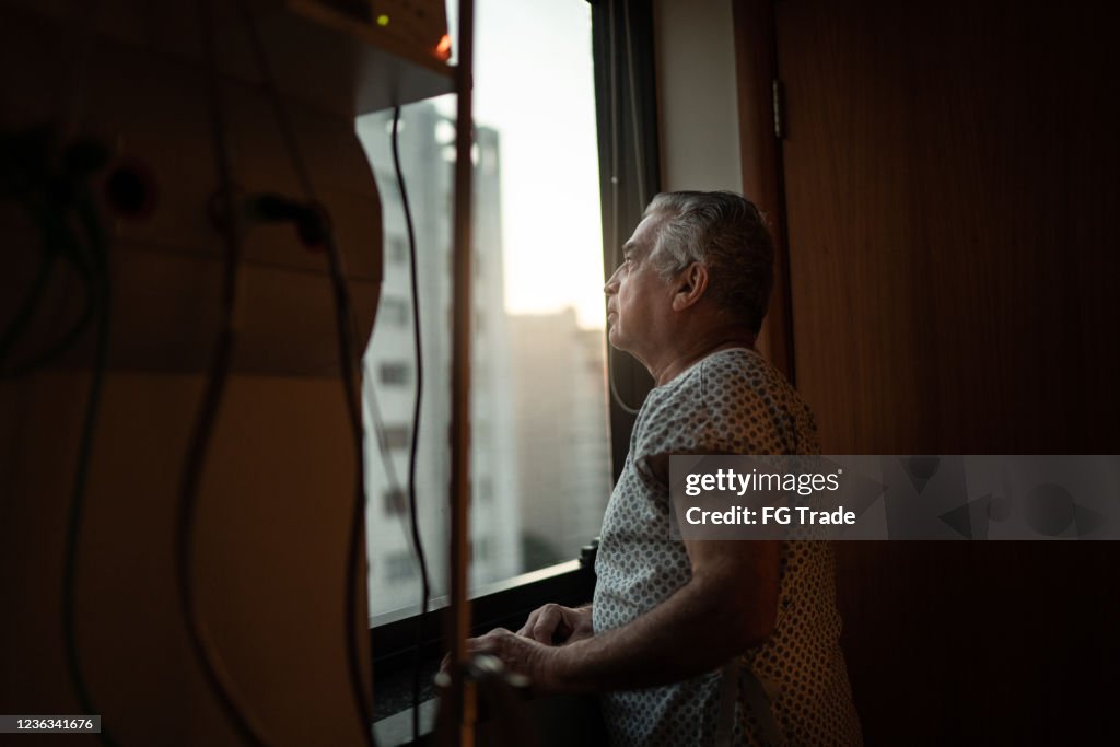 Senior patient looking through window at hospital