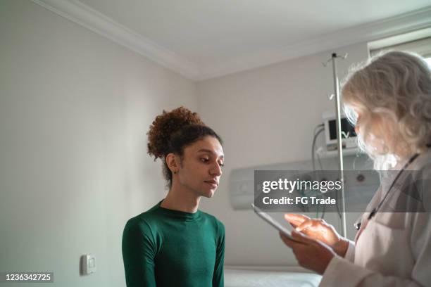 läkare pratar med patient på sjukhusrum med digital tablett - transgender bildbanksfoton och bilder