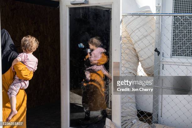 Woman and her child stand in the doorway to their housing tent in an Afghan refugee camp on November 4, 2021 in Holloman Air Force Base, New Mexico....