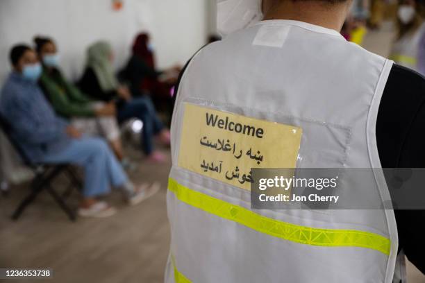 Person wearing a vest with the word "Welcome" in Persian and English is seen in a women's tent in an Afghan refugee camp on November 4, 2021 in...