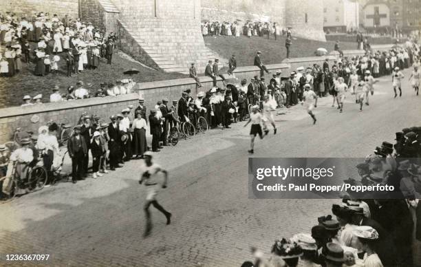 Marathon runners in Thames Street, Windsor during London's Summer Olympic Games on 24th July 1908. The event was won by American Johnny Hayes after...