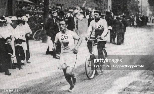 American marathon runner Johnny Hayes, with his cycling attendant George Cameron, lying seventh in Ruislip during London's Summer Olympic Games on...