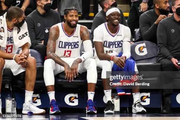 Paul George and Reggie Jackson of the LA Clippers smile on the bench in the fourth quarter of the game against the Minnesota Timberwolves at Target...