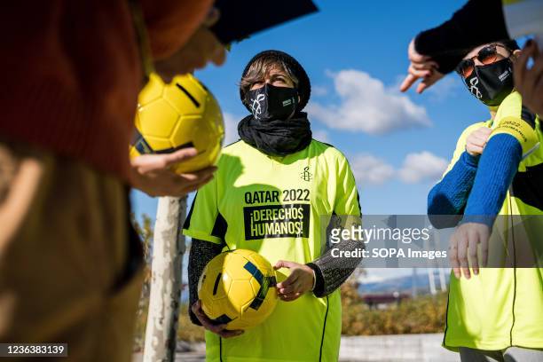 Protesters seen holding soccer balls and wearing sports jerseys demanding the rights of migrant workers in Qatar during the protest in front of the...