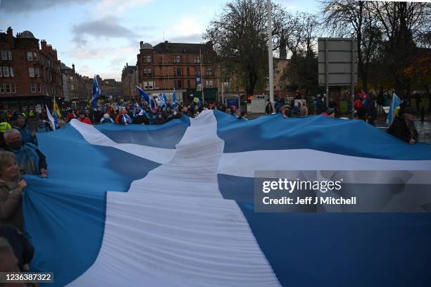 Climate protestors carry a large Saltire flag during the Global Day of Action for Climate Justice march on November 6, 2021 in Glasgow, Scotland. Day...