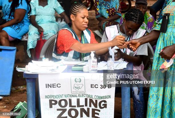 An electoral official accredits a woman to vote at a polling station during the Anambra State governorship election at Uga, Aguata district in...