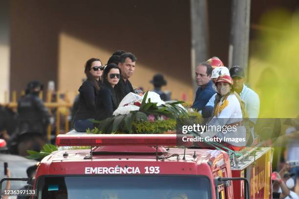 Singers Maiara Carla Henrique Pereira and Carla Maraísa Henrique Pereira sit in a fire truck along the coffin of Brazilian singer Marília Mendonça,...