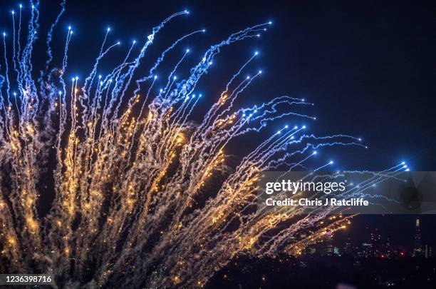 Crowds watch a firework display as part of bonfire night celebrations at Alexandra Palace with a view of the city of London in the distance on...