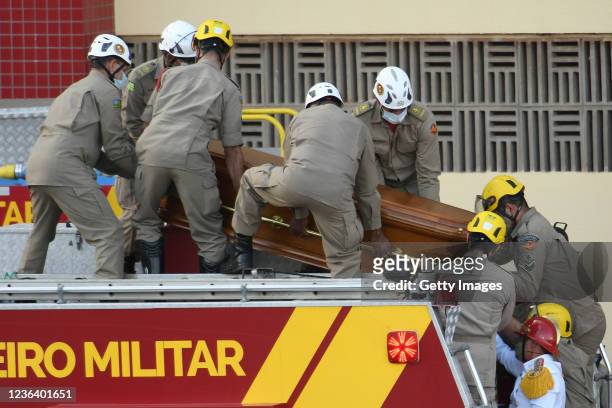 Firefighters place the coffin of Brazilian singer Marília Mendonça, who died in a plane crash, on a fire truck for the funeral procession after the...