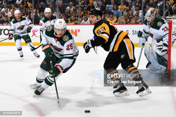 Jonas Brodin of the Minnesota Wild moves the puck in front of Teddy Blueger of the Pittsburgh Penguins at PPG PAINTS Arena on November 6, 2021 in...