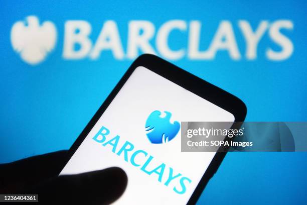 In this photo illustration a Barclays plc logo is seen on a smartphone and a pc screen.