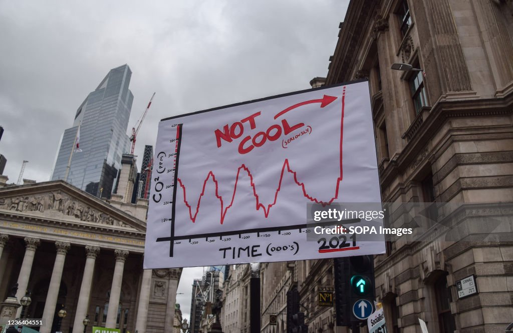 A protester holds a placard with a graph showing increasing...