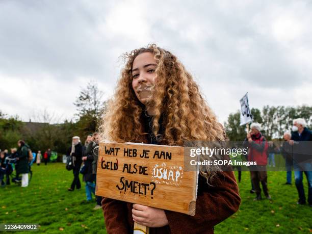 Protester seen holding a placard against wasting money while covering her mouth with tape during the demonstration. The march is organized by the...