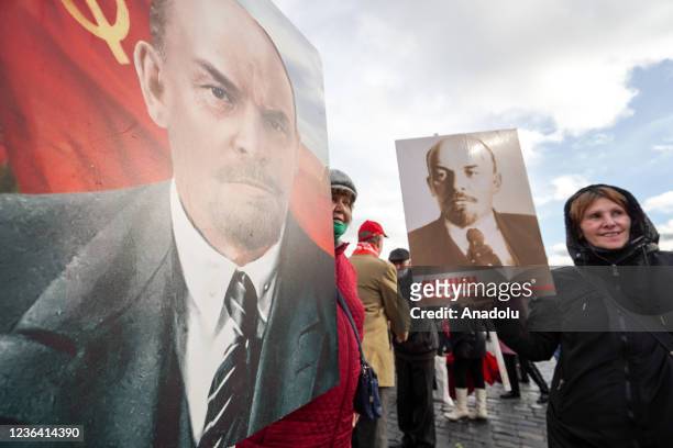 People take part in a ceremony by Lenin's Mausoleum in Red Square and a memorial complex to Heroes of the Revolution by the Kremlin Wall, to mark the...