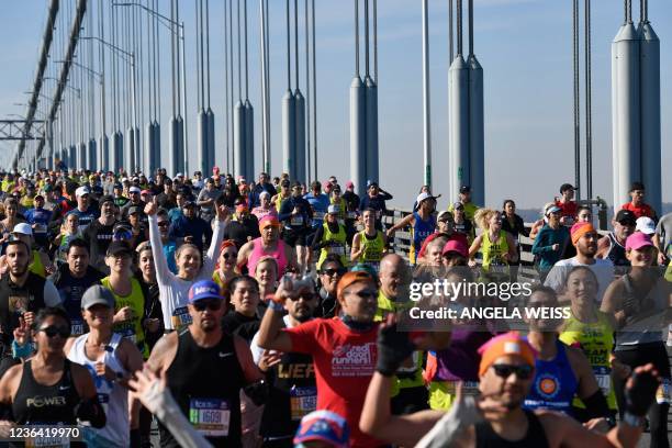 Runners cross the Verrazzano-Narrows Bridge during the 2021 TCS New York City Marathon in New York on November 7, 2021. - After a forced break in...