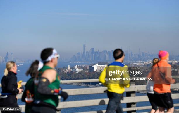 Runners cross the Verrazzano-Narrows Bridge during the 2021 TCS New York City Marathon in New York on November 7, 2021. - After a forced break in...