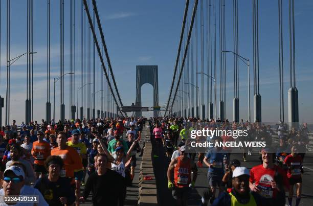 Runners cross the Verrazzano-Narrows Bridge during the 2021 TCS New York City Marathon in New York on November 7, 2021. - After a forced break in...