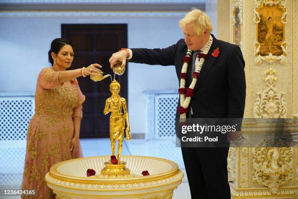 Prime Minister Boris Johnson and Home Secretary Priti Patel pour water over a gilded brass image of Shri Nilkanth Varni in a Abhishek ceremony as...