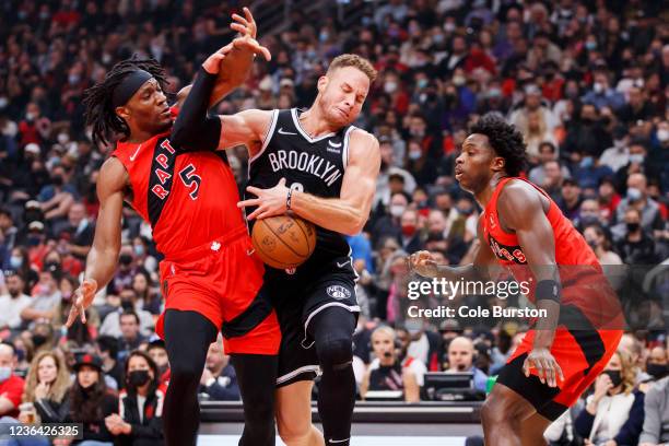 Blake Griffin of the Brooklyn Nets is stripped of the ball by Precious Achiuwa of the Toronto Raptors as OG Anunoby defends during the first half of...