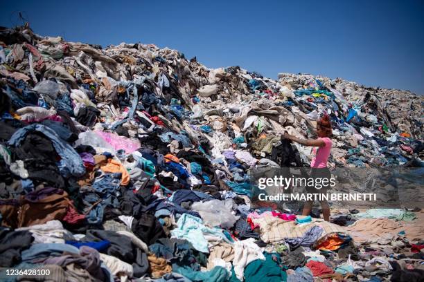 Women search for used clothes amid tons discarded in the Atacama desert, in Alto Hospicio, Iquique, Chile, on September 26, 2021. EcoFibra, Ecocitex...
