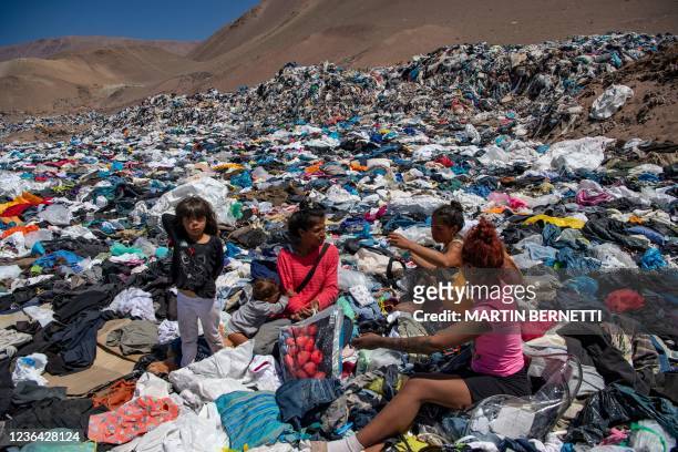 Women search for used clothes amid tons discarded in the Atacama desert, in Alto Hospicio, Iquique, Chile, on September 26, 2021. EcoFibra, Ecocitex...