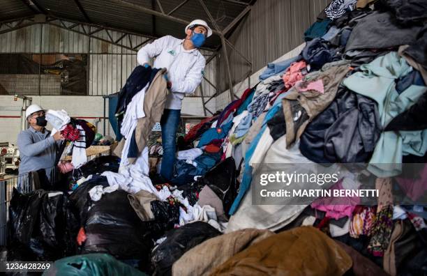 Men work at a factory that recycles used clothes discarded in the Atacama desert for wooden isolation panels for the walls of social housing, in Alto...