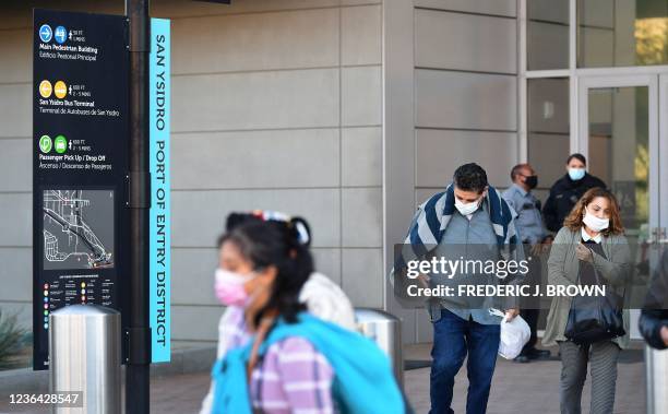 People wear facemasks upon entry into the United States at the San Ysidro Land Port of Entry in San Ysidro, California on November 7 one day before...