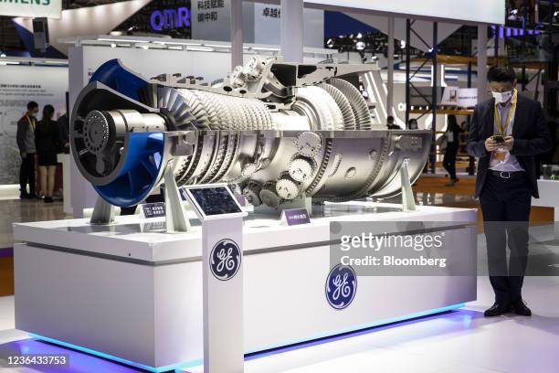 Visitors look at a model of the 9HA gas turbine at the General Electric Co. Booth at the China International Import Expo in Shanghai, China, on...