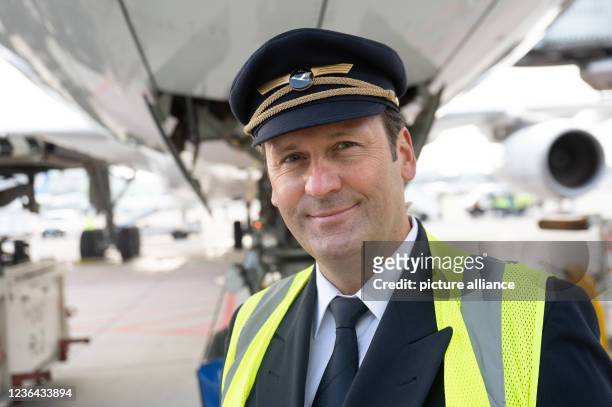 November 2021, Hessen, Frankfurt/Main: Lufthansa captain Frank Dunz stands in front of his plane at Frankfurt Airport, which he will fly to New York....