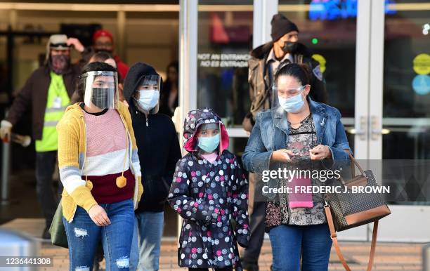 People wear facemasks and faceshields upon entry from Mexico into the United States at the San Ysidro Land Port Entry in San Ysidro, California on...