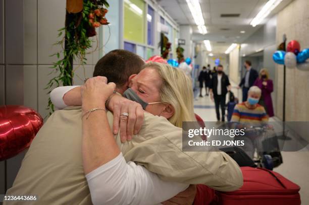 Alison Henry embraces her son Liam as they meet after arriving on a flight from the UK, following the easing of pandemic travel restrictions at JFK...