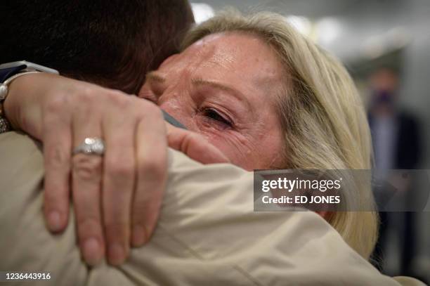 Alison Henry embraces her son Liam as they meet after arriving on a flight from the UK, following the easing of pandemic travel restrictions at JFK...