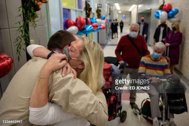 Alison Henry embraces her son Liam as they meet after arriving on a flight from the UK, following the easing of pandemic travel restrictions at JFK...