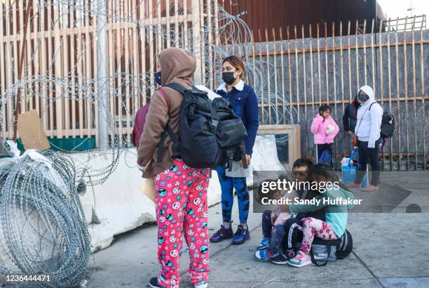 Pedestrians wait in line to cross the border at the San Ysidro Port of Entry on November 8, 2021 in Tijuana, Mexico. Monday was the official opening...