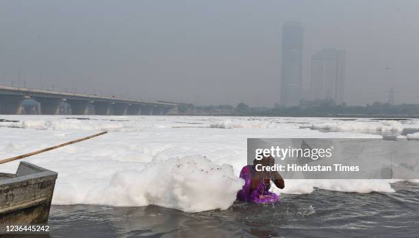 Woman performs rituals on the bank of Yamuna river ahead of Chhath Puja, at Kalindi Kunj, on November 8, 2021 in New Delhi, India. The heavily...