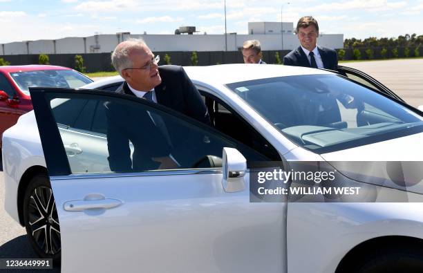 Australian Prime Minister Scott Morrison and Australia's Minister for Energy and Emissions Reduction Angus Taylor prepare to drive a hydrogen-powered...