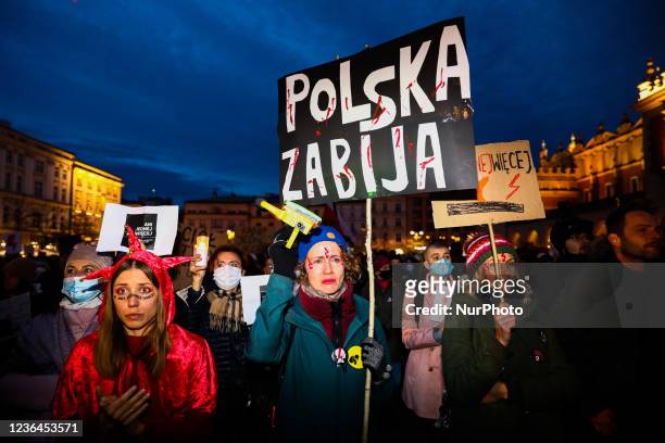 Woman holds a banner reading 'Poland kills' during 'Not one more! March for Iza' protest after 30-year-old woman, Iza, died of septic shock in her...