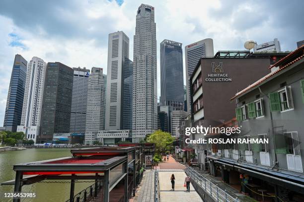 People walk along Boat Quay towards the financial business district in Singapore on November 9, 2021.