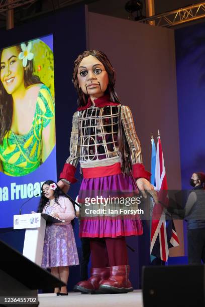 Little Amal, a 3.5 metre-tall puppet depicting a Syrian refugee girl, on stage with Brianna Fruean, a Samoan member of the Pacific Climate Warriors,...