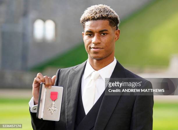 Manchester United and England footballer Marcus Rashford poses with his medal after being appointed a Member of the Order of the British Empire for...